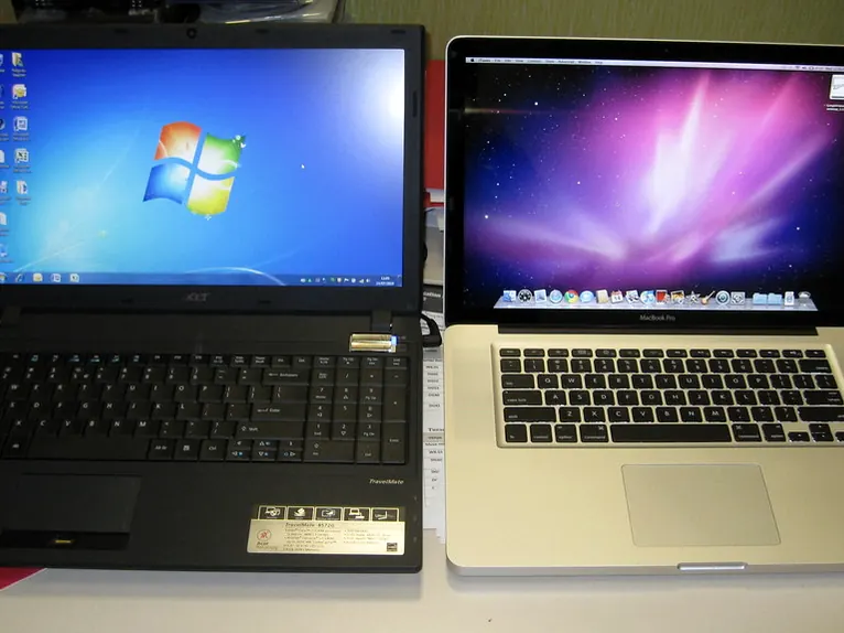 Two older laptops side by side on a desk